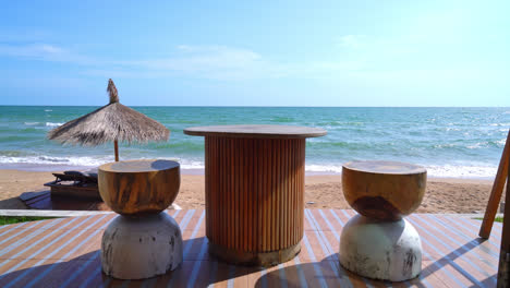 wood table and chair on balcony with sea beach background