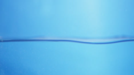 water droplets fall from above, creating smooth circular ripples on the surface, representing purity, health, and refreshing clean liquid.