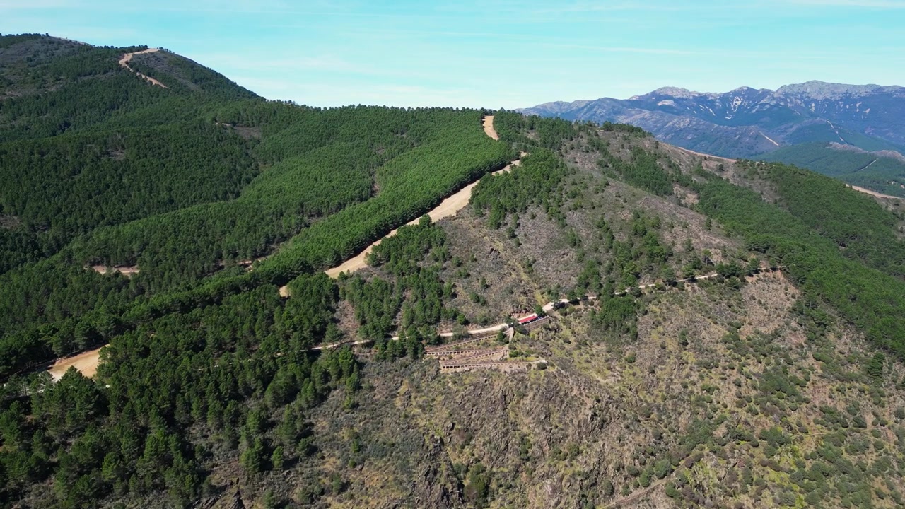 Un lussureggiante paesaggio montano con strade sterrate tortuose che attraversano fitte foreste. Ideale per documentari sulla natura e contenuti di viaggio.