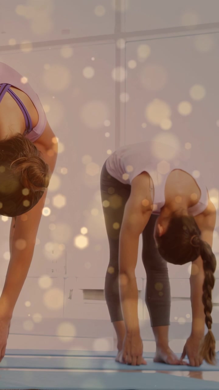 Video verticale: Yogi con trecce che si piega verso le punte dei piedi mantenendo l'allungamento, si alza su un segnale di yoga con bokeh dorato su una coppia.