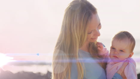 animation of glowing spots over happy caucasian mother kissing her baby