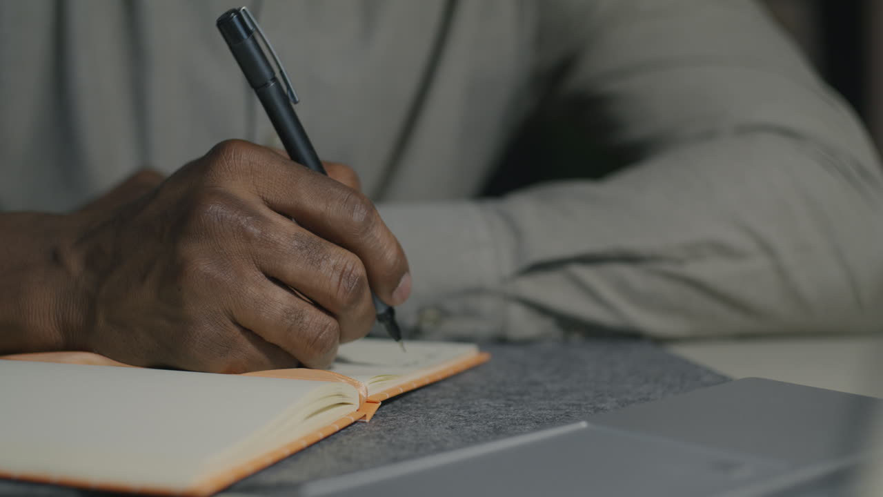 Person Writing in a Notebook