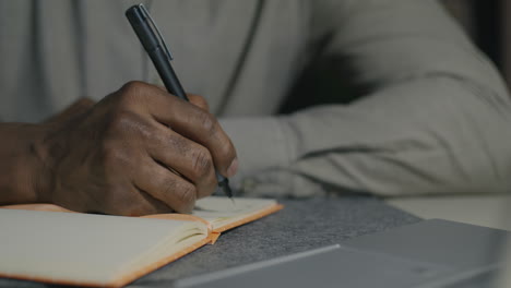 persona que escribe en un cuaderno