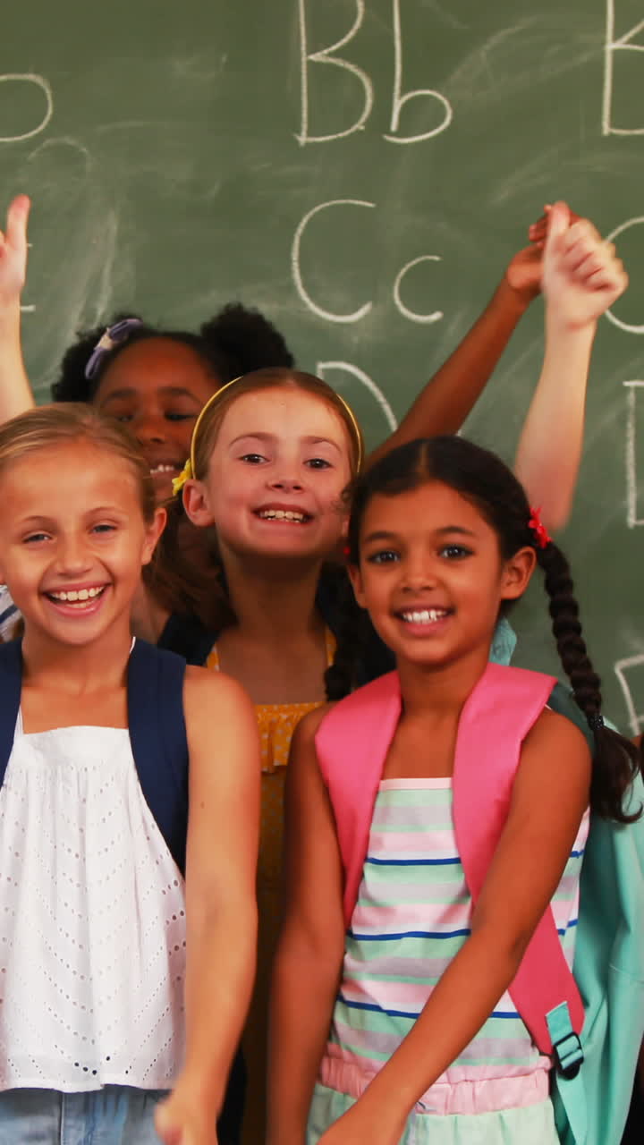 Smiling kids showing thumbs up in classroom