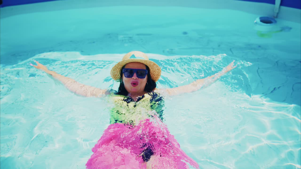 Woman in colorful swimsuit enjoying a sunny day in a swimming pool with vibrant water reflections