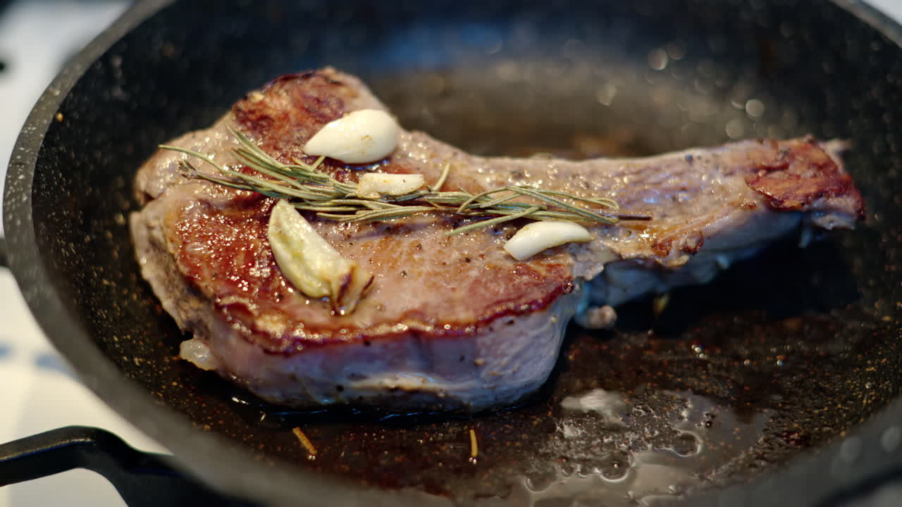 Juicy ribeye steak meat beef being prepared with rosemary and garlic