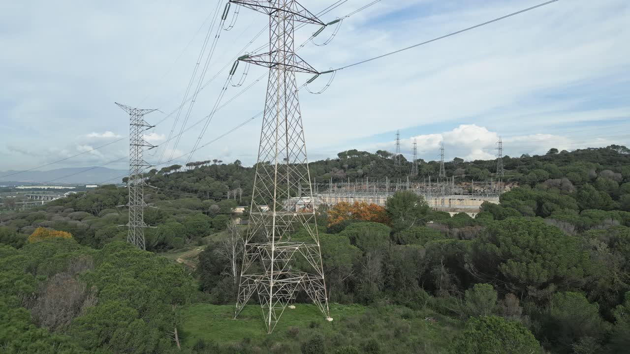 Power lines and an electrical substation are nestled within a wooded area, underscoring the intersection of nature and infrastructure in energy distribution near barcelona