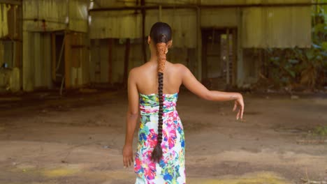 a young african queen walks and enjoys herself before spinning in a 360 motion at an abandoned warehouse