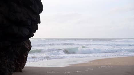 violent sea waves crashing at a beach of praia da adraga in portugal