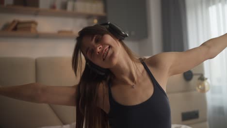 mujer escuchando música y bailando en el dormitorio
