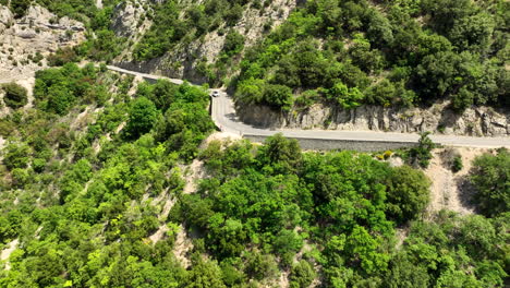 Car-Drives-on-a-Sunny-Canyon-Road-in-Verdon-Gorge---Aerial-Approach