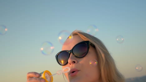 Mujer-Joven,-En,-Gafas-De-Sol,-Soplar,-Pompas-De-Jabón