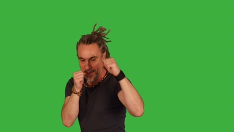 martial artist doing fighting training isolated on green screen background. energetic mid age rasta man boxing against camera.