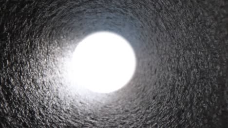 bright white light at end of gray pipe closeup