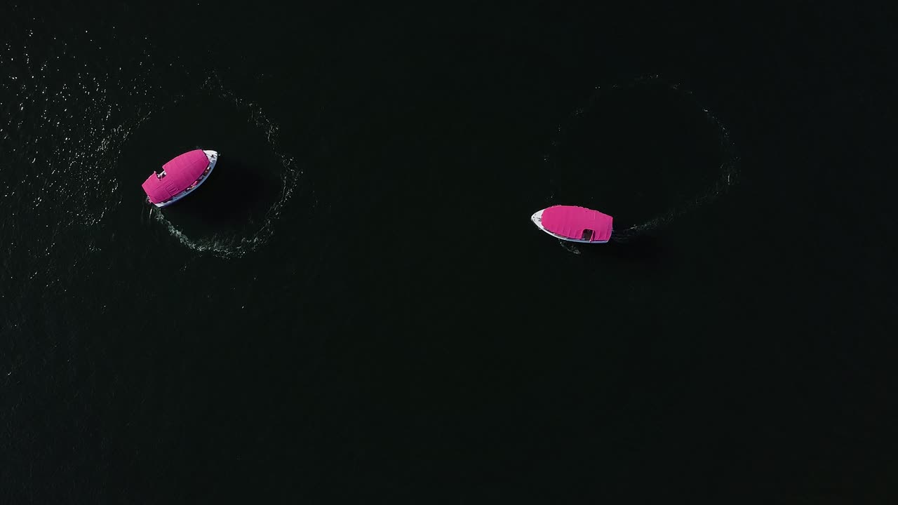 two pink party boats doing circles