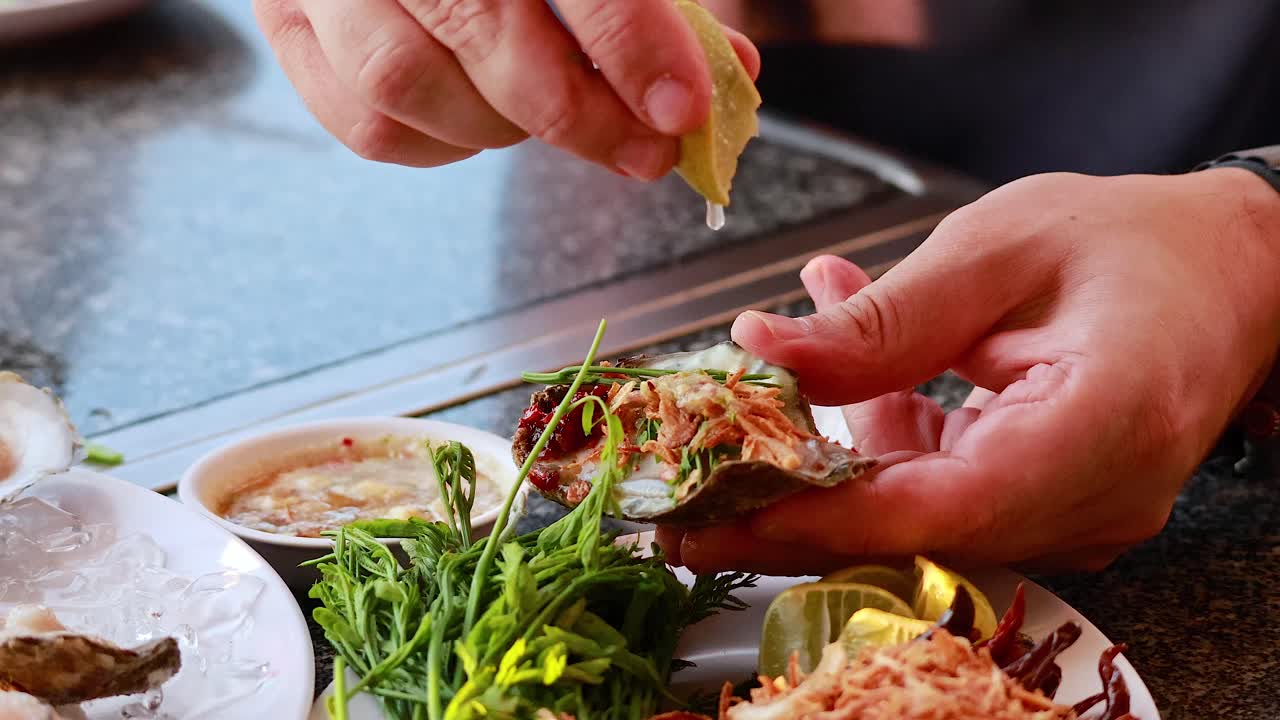 손은 허브와 레몬으로 오스트리를 준비하고 있습니다.