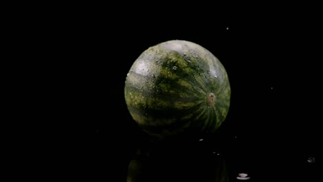 Wassertropfen-Fallen-Auf-Wassermelone-Einzeln-Auf-Schwarzem-Hintergrund,-Zeitlupe