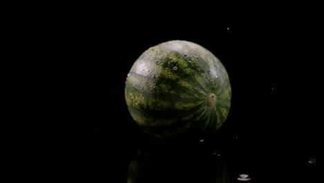 water drops falling on watermelon isolated on black background, slow motion