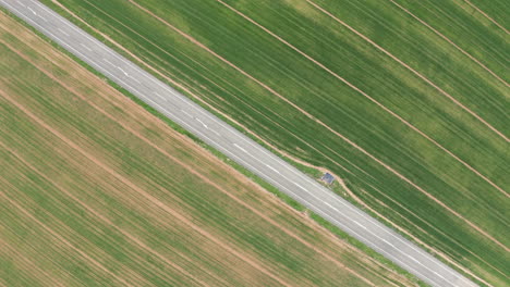 green grass texture background fields aerial top shot with a road passing