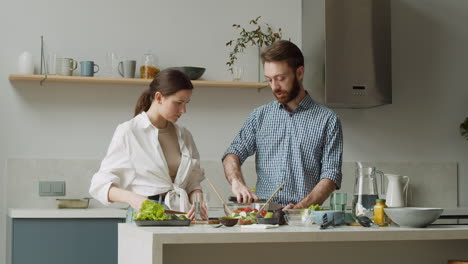 Pareja-Preparando-Ensalada-Juntos-Y-Cortando-Aguacates-En-Una-Cocina-Moderna