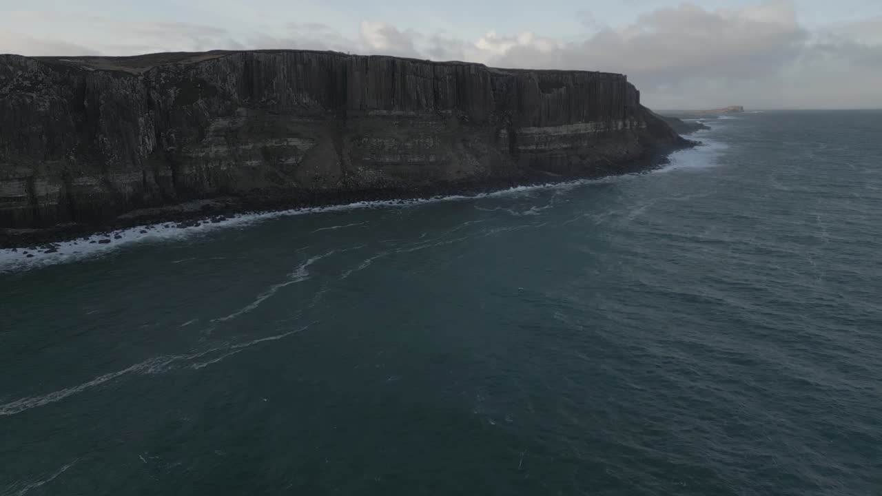 The rugged kilt rock cliffs in skye, scotland, with waves crashing against the shore, aerial view