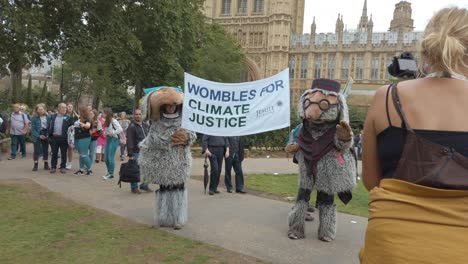 climate change protestors lobby along the banks of the thames and outside the houses of parliament as part of the time is now protest
