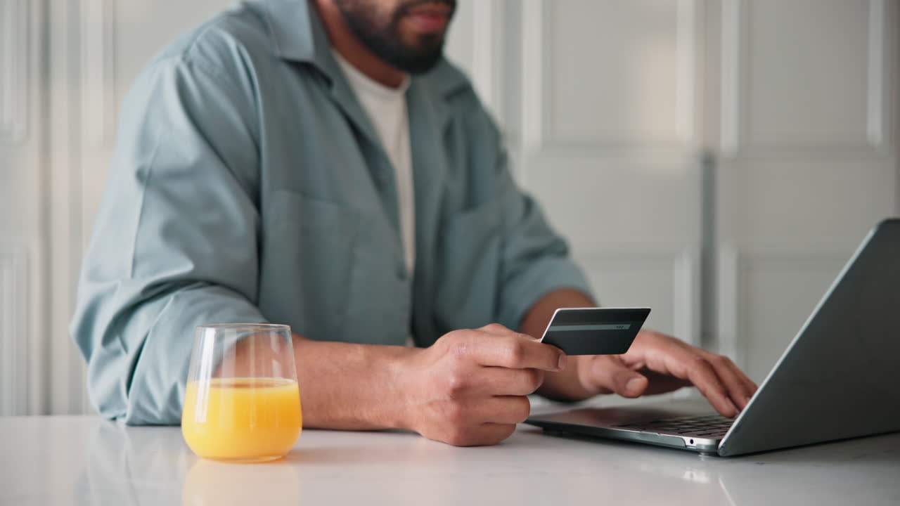 Uomo che usa un laptop e una carta di credito per effettuare un acquisto online