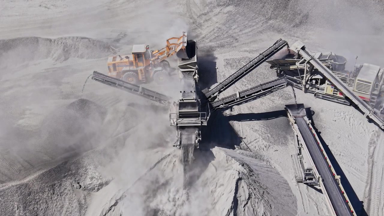 Heavy machinery operates in a quarry during daylight hours