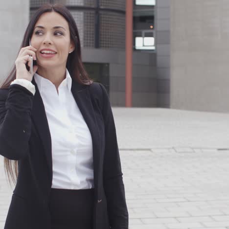Attractive-businesswoman-checking-her-mobile-teléfono
