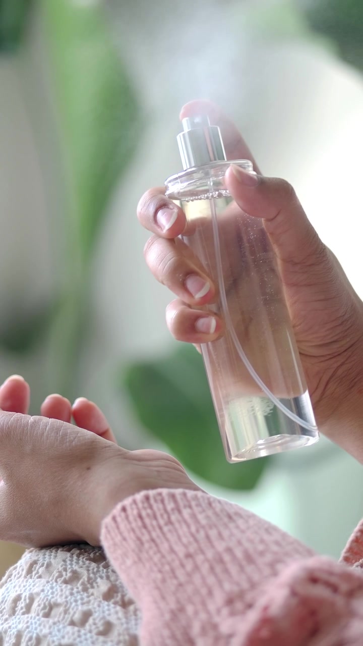 Persona che spruzza profumo sul polso