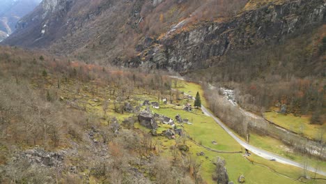 Tomando-Una-Panorámica-De-Izquierda-A-Derecha-Del-Encuadre,-Una-Toma-De-Un-Dron-Muestra-Las-Casas-De-Piedra-En-El-Pueblo-De-Cavergno,-Ubicado-En-El-Distrito-De-Vallemaggia-En-Suiza.