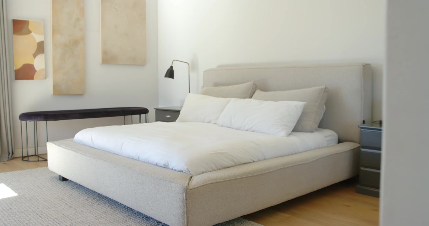 Camera is sliding from bedroom doorway revealing beige bed dresser lamp sunlight showcasing layout