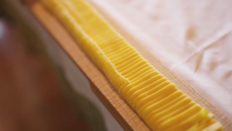 close up shot of a bunch of italian handmade pasta over a raw wood chopping board