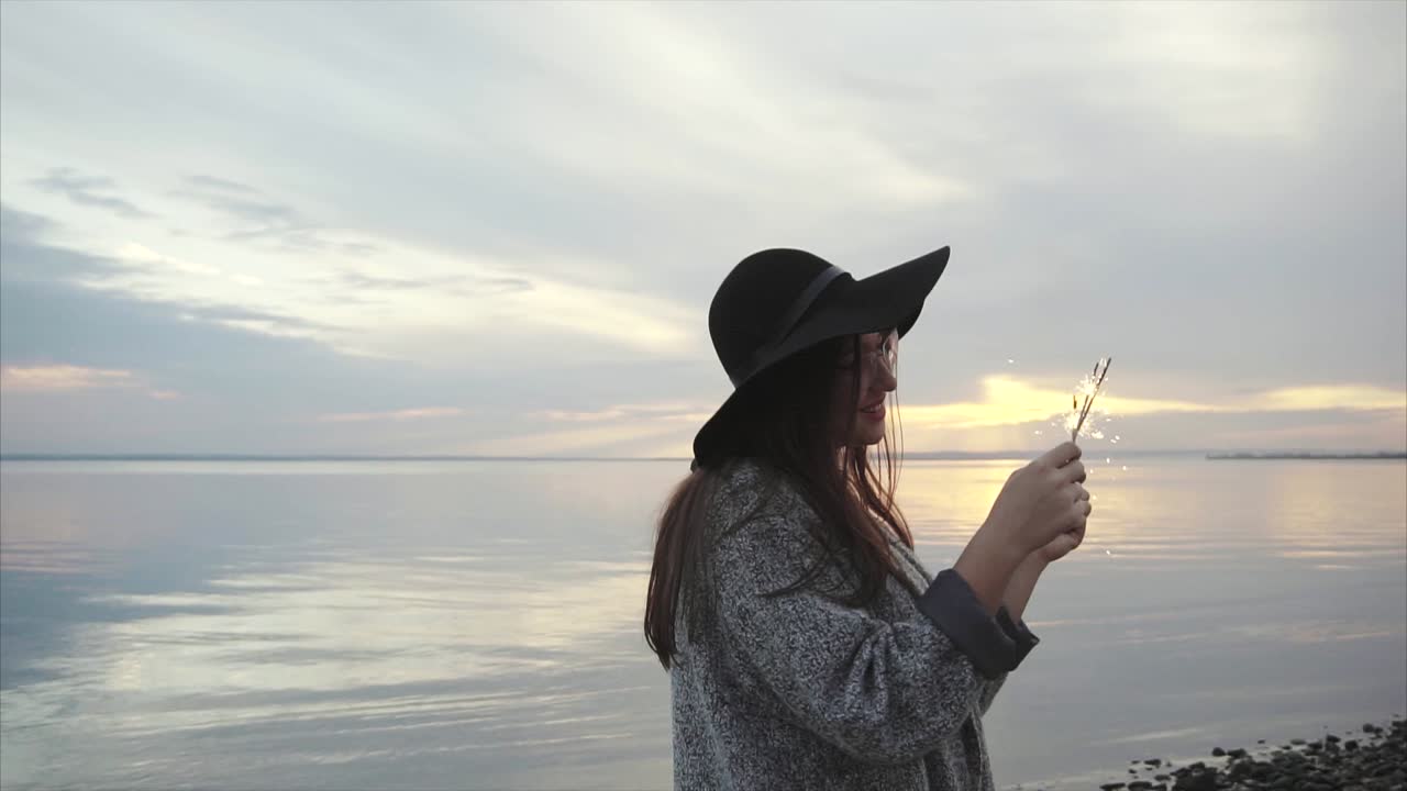 женщина с искрами на закате у озера