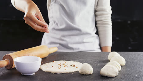 woman adding dry fruits over flattened dough 4k