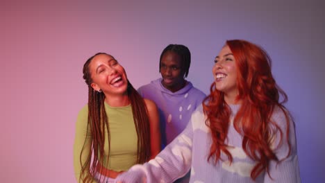 studio shot of young gen z friends dancing at club against pink background 2