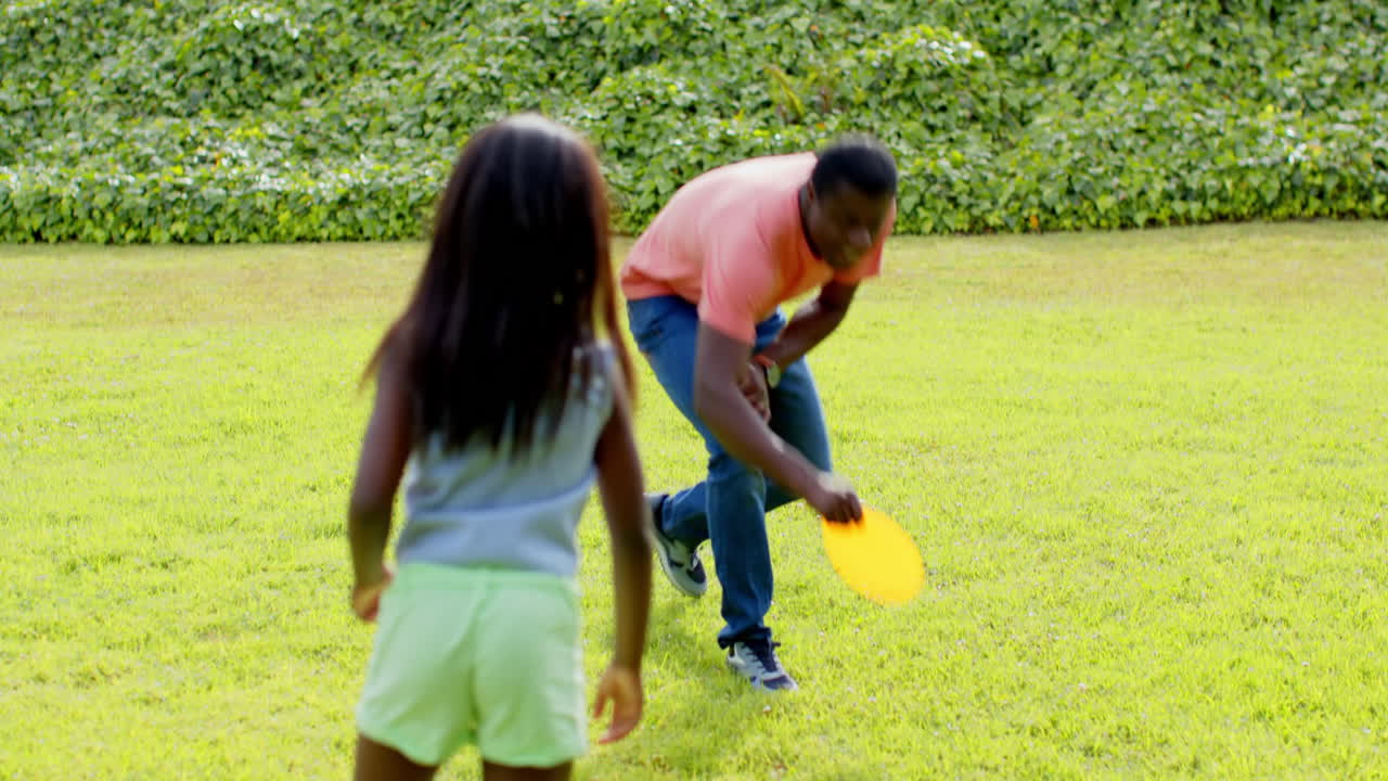 African American, Father and daughter playing catch in sunny park, enjoying outdoor fun together