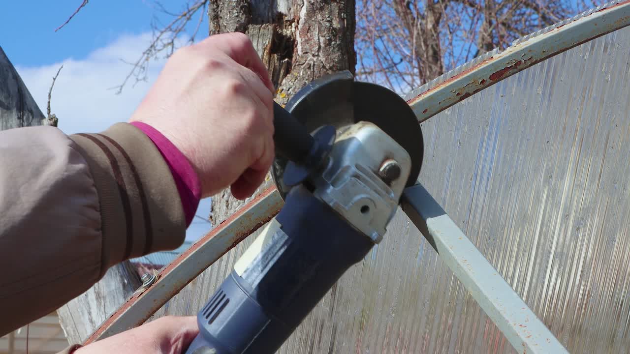 밀러를 가진 남성의 손은 하늘의 배경에 대해 파이프를 잘라