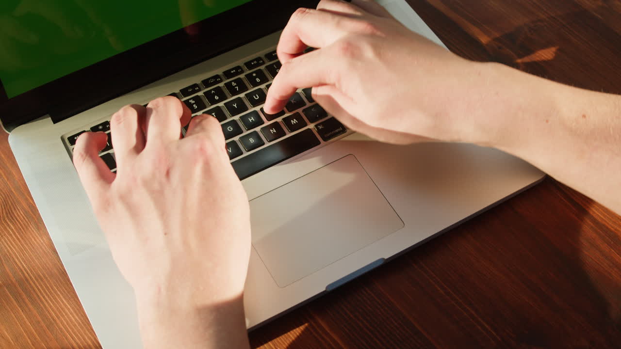 Hands Typing on Laptop Keyboard with Green Screen