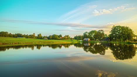 A-mesmerizing-time-lapse-video-showcases-a-picturesque-village-with-a-pond-while-the-sky-above-undergoes-enchanting-transformations,-creating-a-truly-awe-inspiring-scene