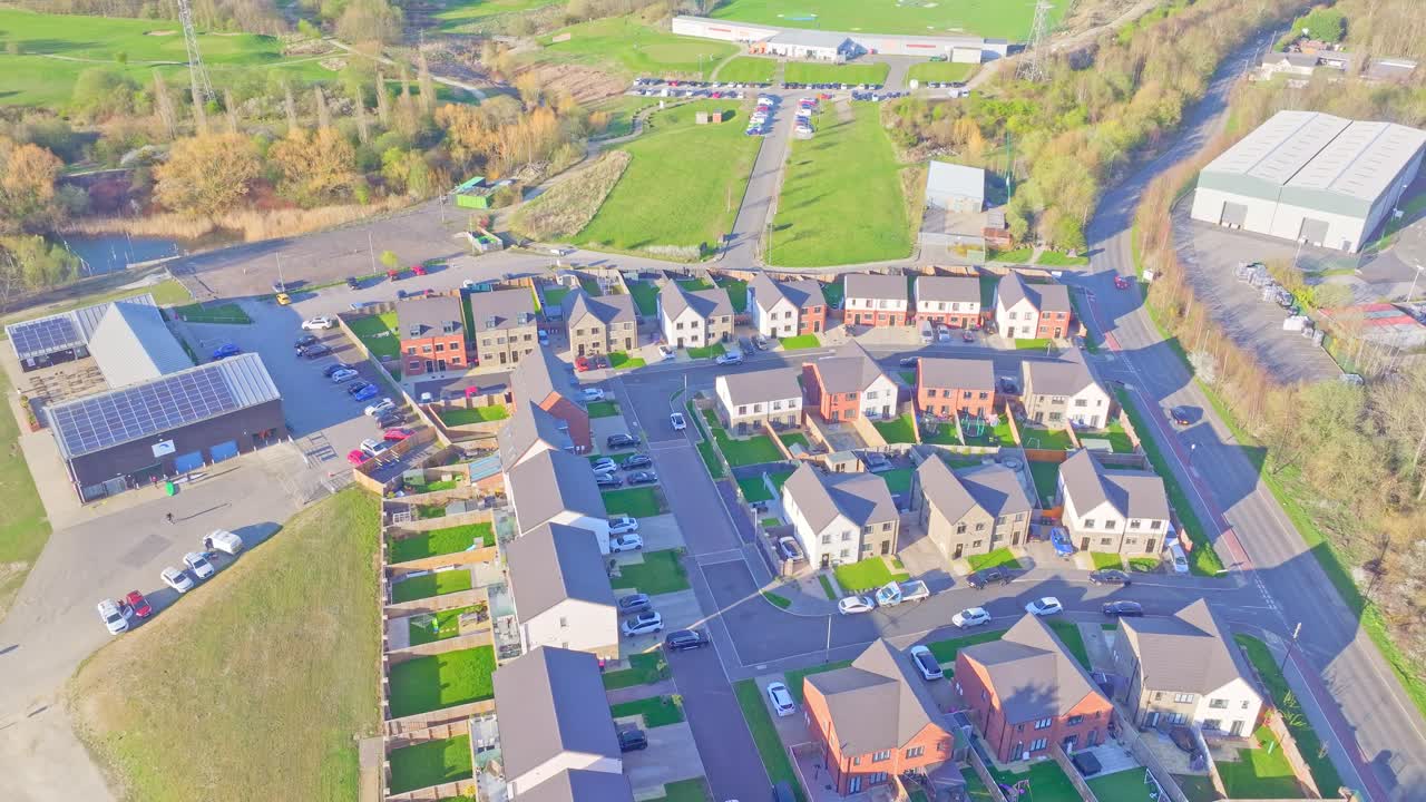 Overhead drone shot showing Manvers Waterfront Boat Club and adjacent housing development with green gardens and access roads in Rotherham, UK, captured in real time during daylight