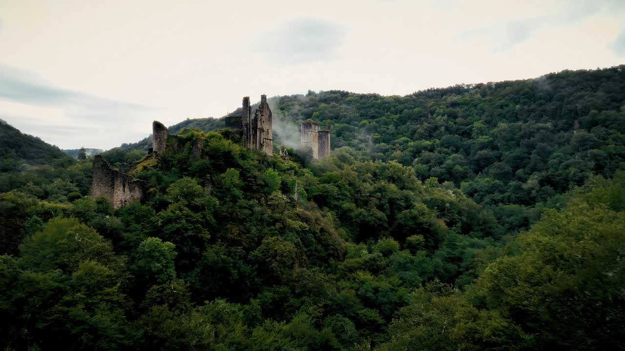 close-up drone shot of a ruined castle abandoned in a forest, a little mist surrounds it