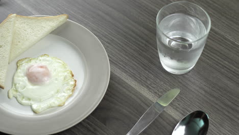 hot dog served on a plate.place the hot dog on a plate that contains eggs and bread