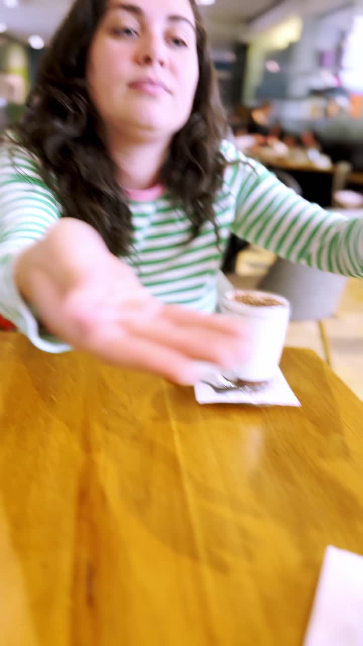 Giovane donna in caffetteria consegna il tablet del menu.