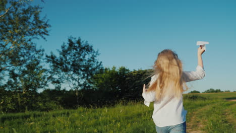 A-Girl-With-Long-Hair-Runs-With-A-Paper-Airplane-In-Her-Hand-Baby-Dreams-Concept-Steadicam-Shot