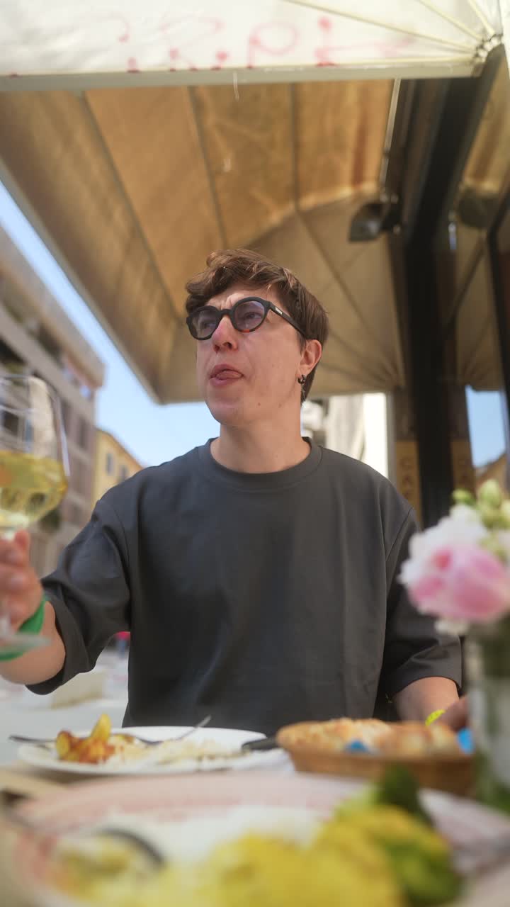 Young man enjoying a meal and wine at an outdoor cafe
