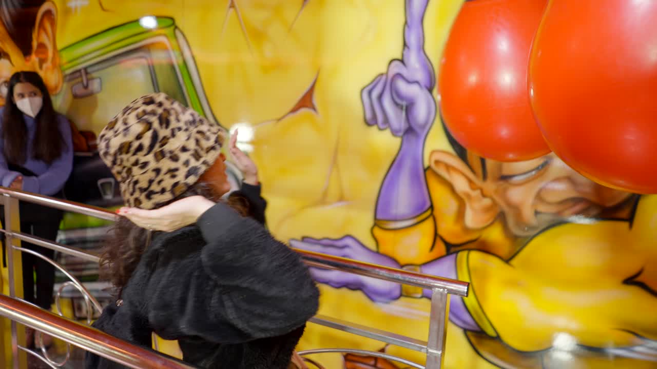 Woman Playing a Punching Bag Game at an Amusement Park