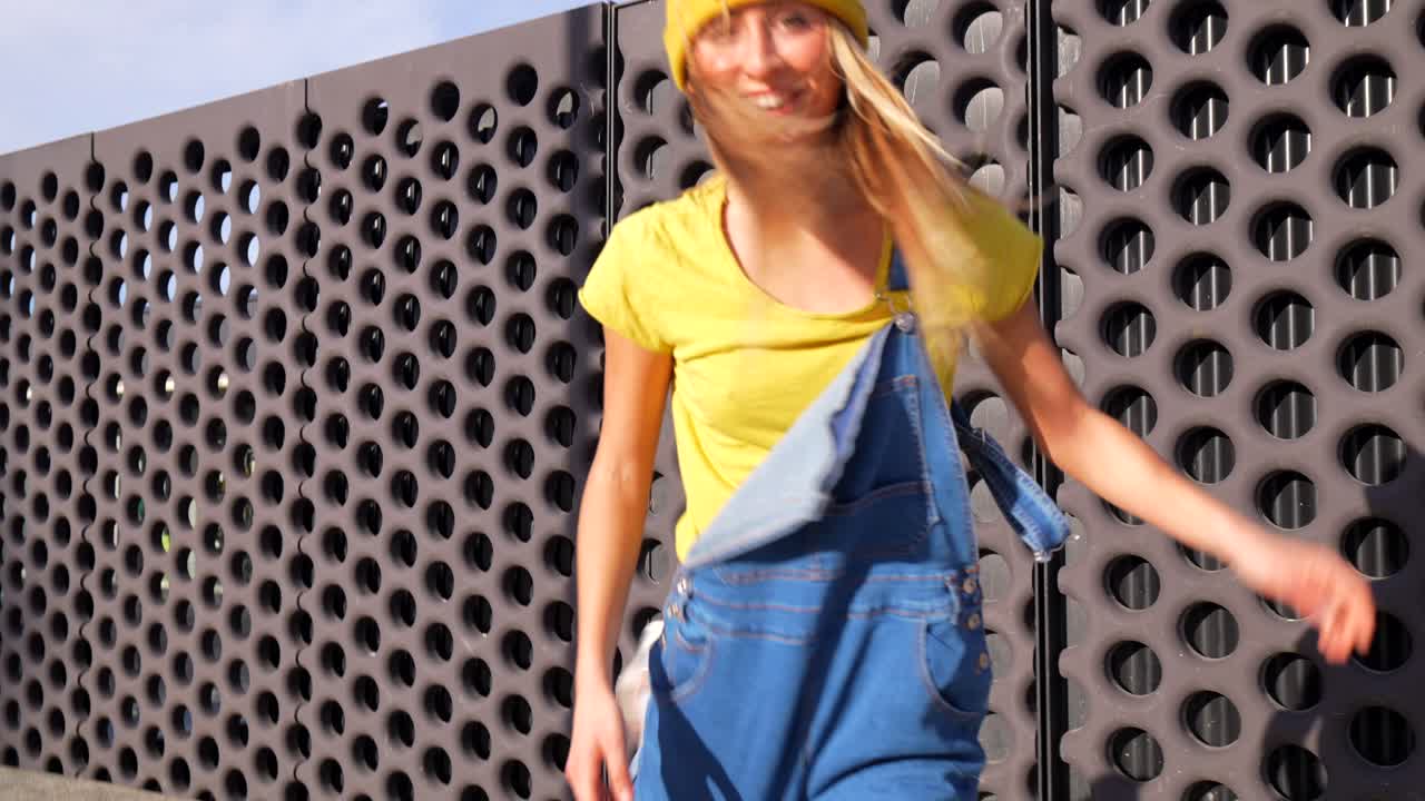 Woman in yellow beanie dancing on the street