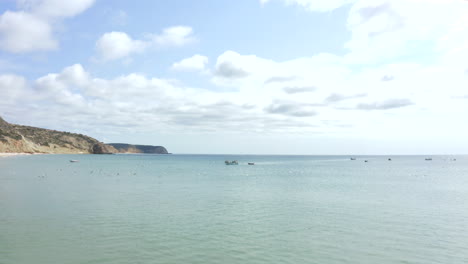 Fisherman-Boat-Sailing-At-The-Praia-Do-Burgau-Beach-In-Algarve,-Portugal