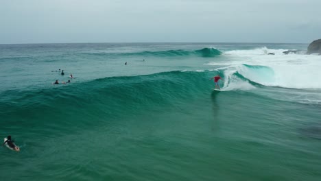 Tracking-drone-shot-of-a-surfer-riding-a-clear-wave-at-Tofinho-Point,-Mozambique